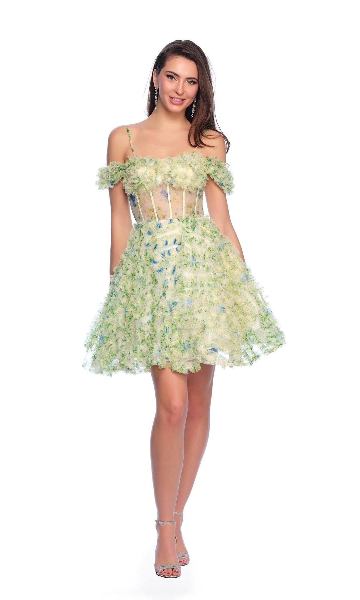 A woman models the Dave and Johnny Short Green Print Hoco Dress 11767, featuring a sheer corset bodice and off-shoulder floral details, with strappy heels against a white background.